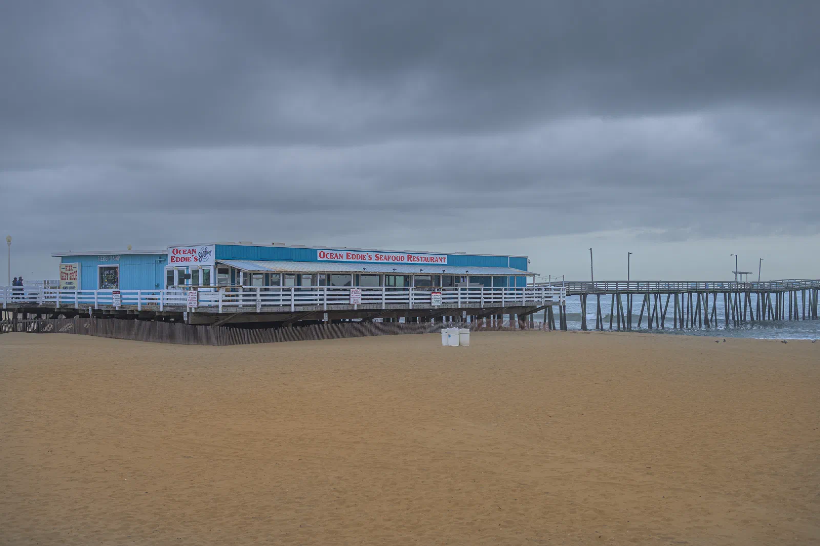 Ocean Eddie's restaurant beside a pier under cloudy skies